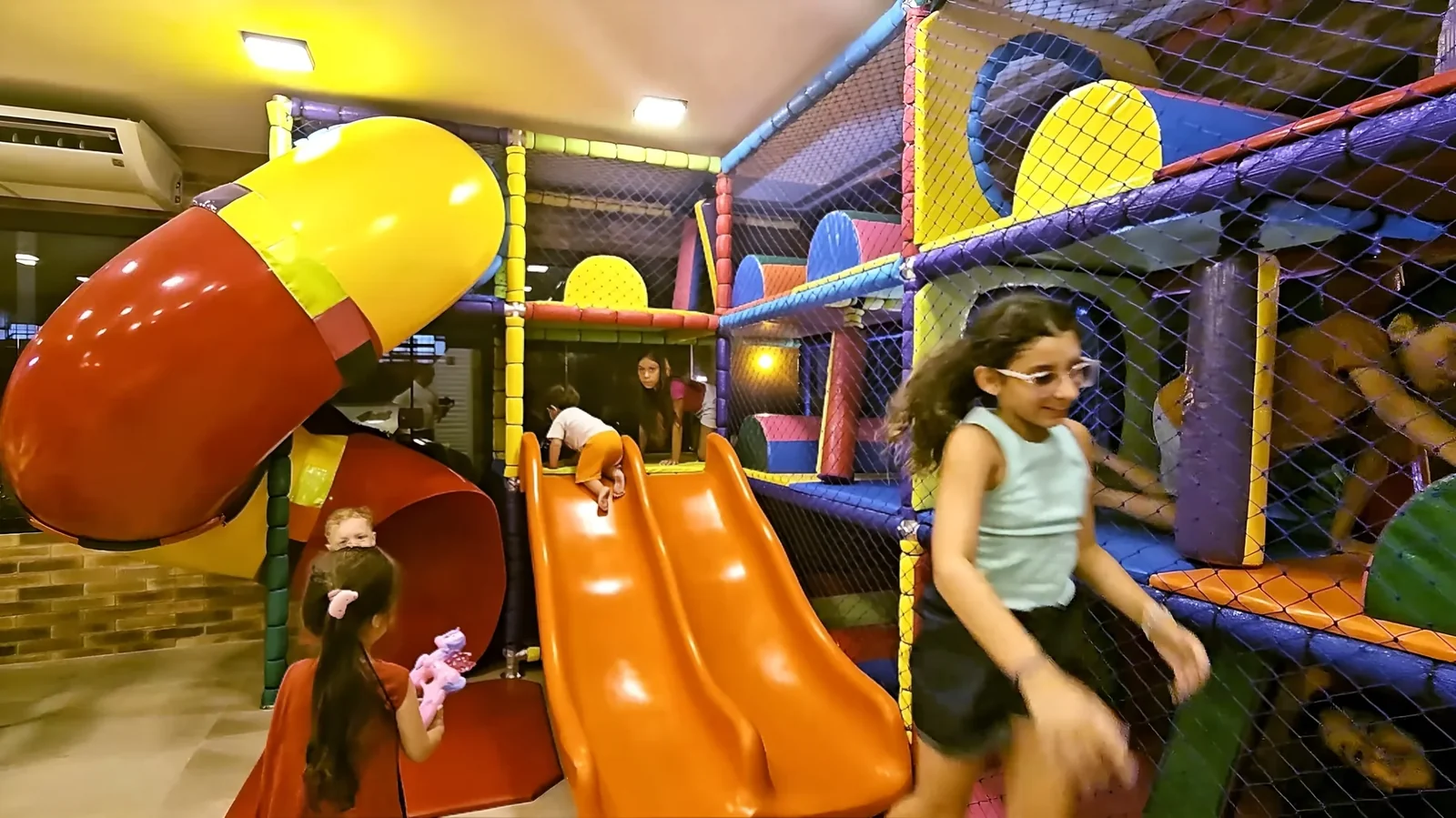 Crianças brincam nos escorregadores coloridos do Espaço Kids